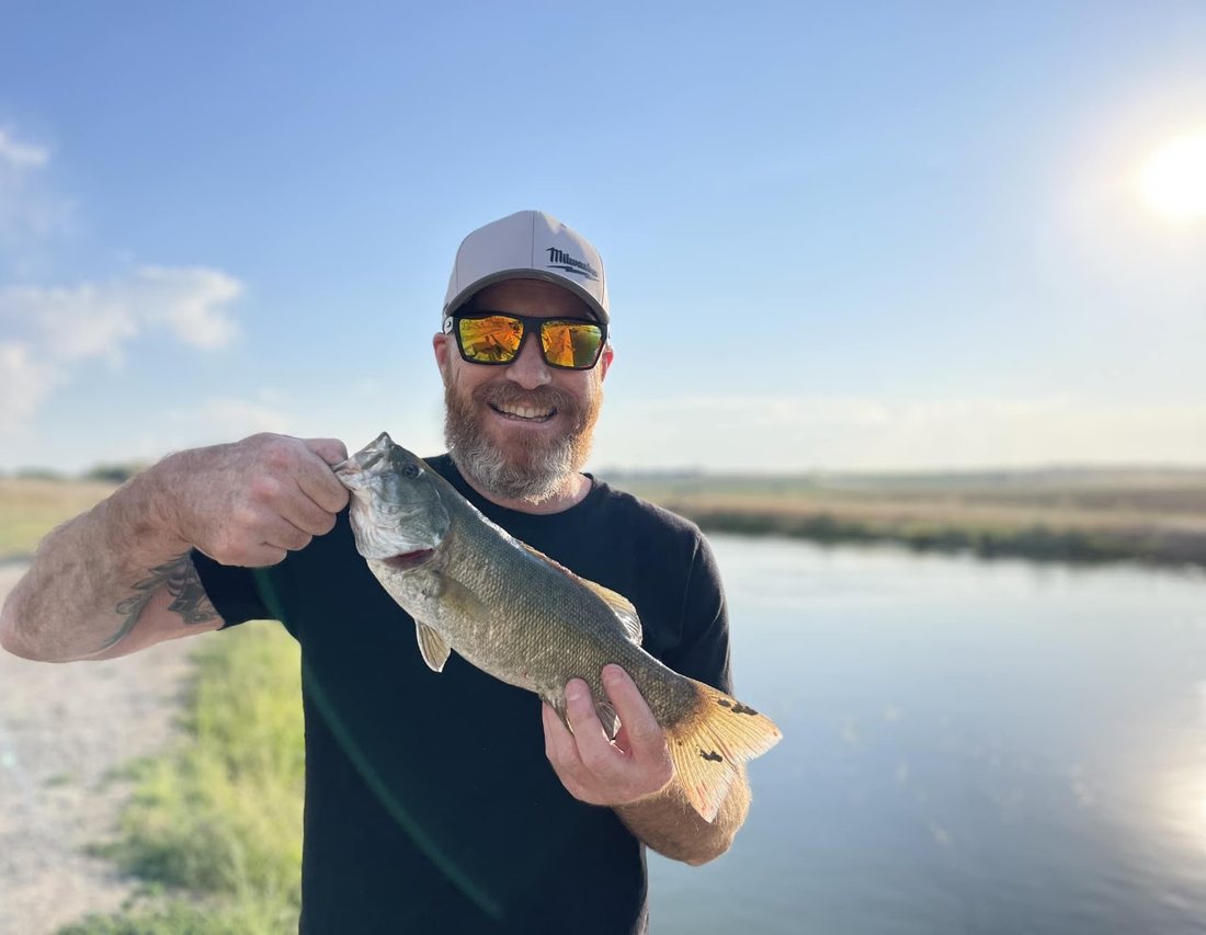 Brian Lenney holding a bass he caught